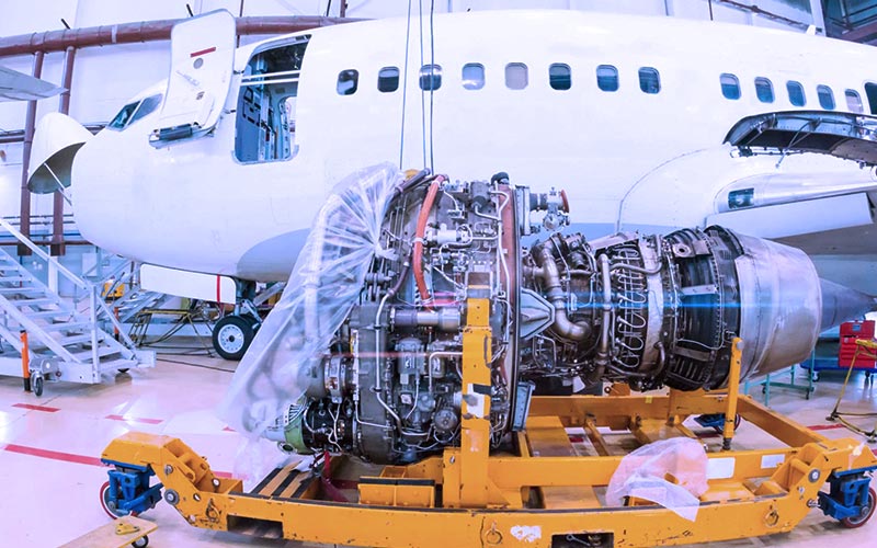 Durante ma manutenção do tipo overhaul de um motor turbofan, o motor é retirado completamente da aeronave. A imagem demonstra o motor sendo retirado da aeronave.